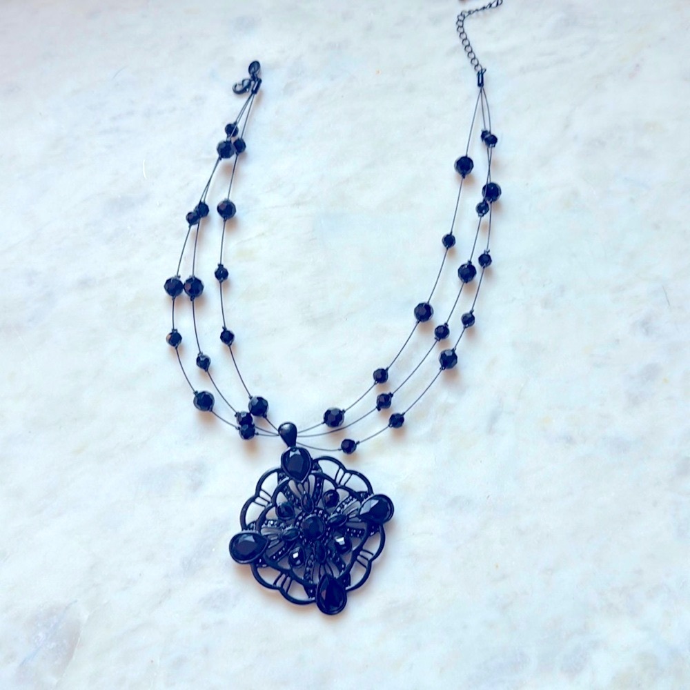 Black gemstone pendant with adjustable chain.